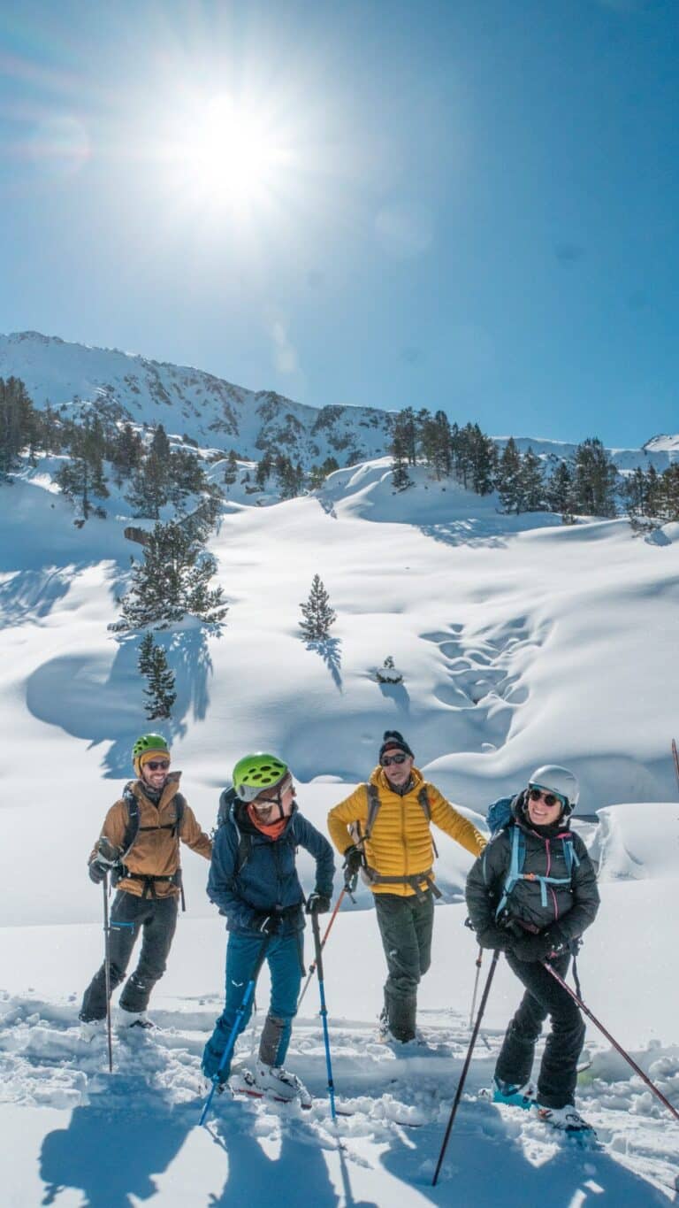 Groupe de skieurs de randonnée devant les lacs et pins enneigés du Néouvielle